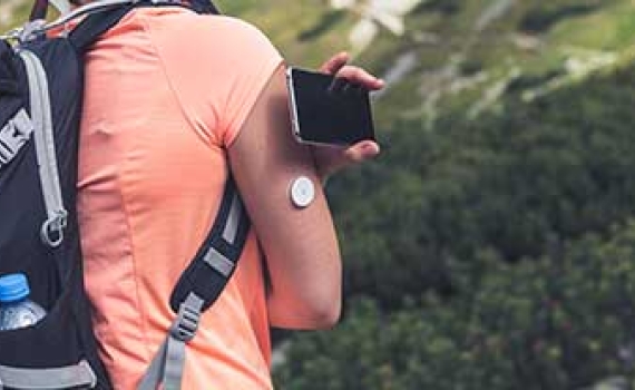 female hiker checking gluecose level with remote sensor