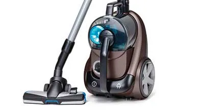 A brown and black bagless canister vacuum with a transparent dustbin, silver wand, and floor head, set against a white background.
