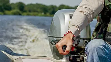 Person steering a boat with an outboard motor, leaving a wake.