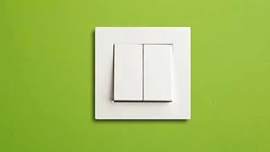 A white double light switch on a bright lime green wall.