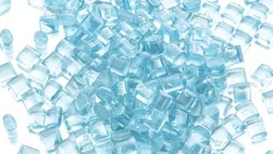 A small pile of translucent light-blue plastic pellets on a white background.