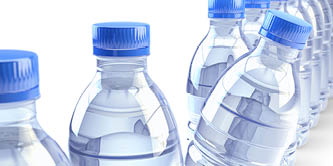 Row of plastic bottles with clear drinking water and blue caps, isolated on white background
